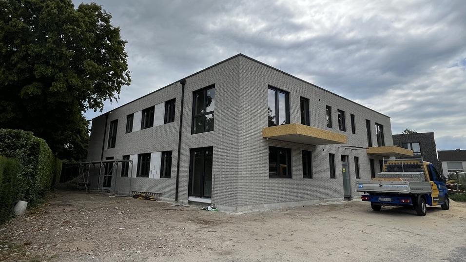 Verklinkerter Neubau mit Firmenwagen auf dem Bild